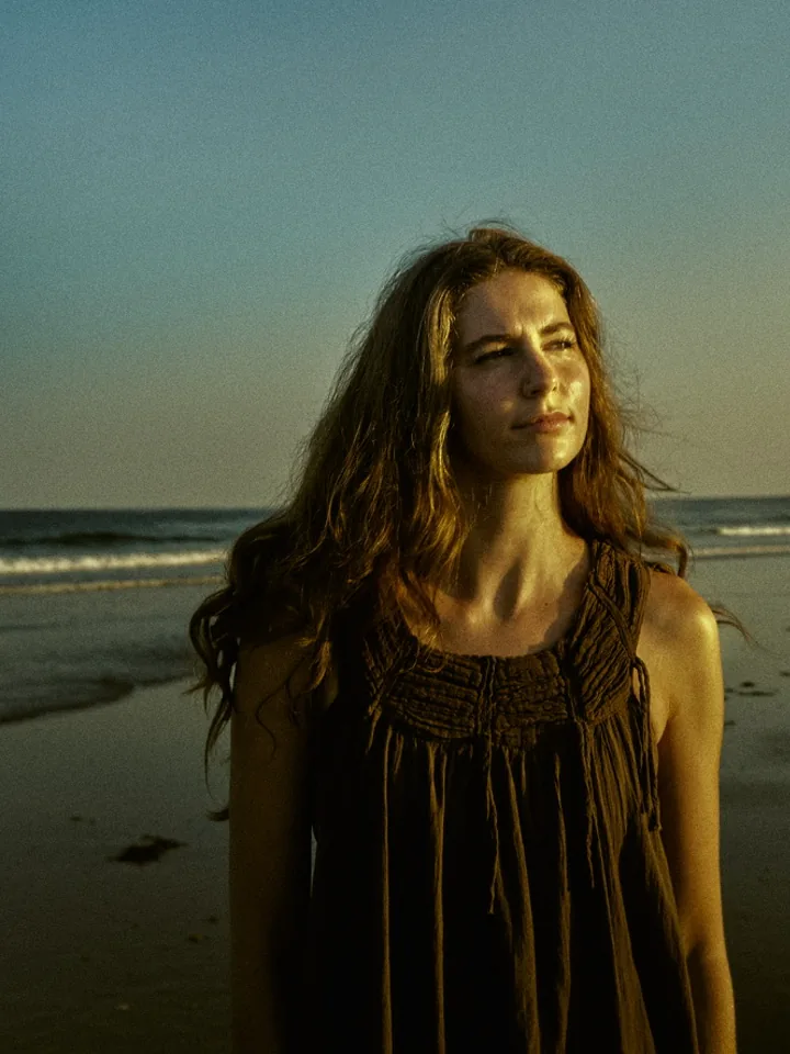 Golden hour portrait of Allie on a beach looking out over the ocean