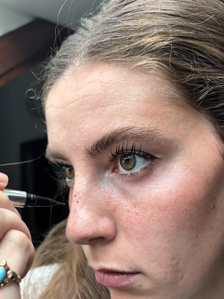 Close-up of an eyebrow being filled in with a pencil during a beauty routine